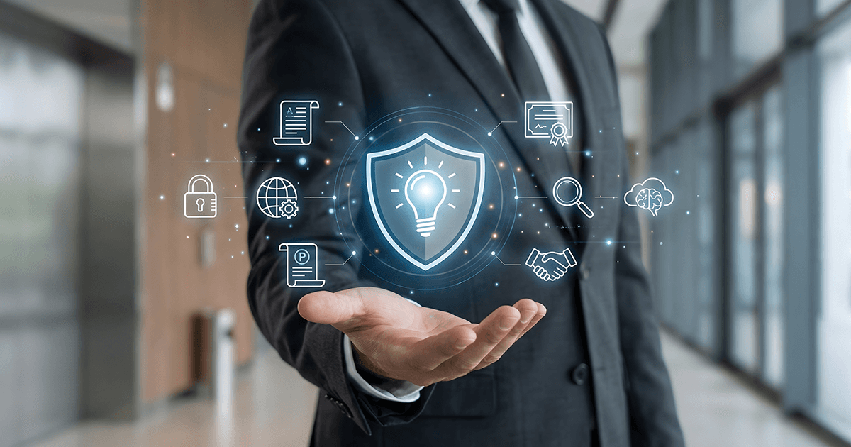 Businessman in suit holding glowing shield with lightbulb surrounded by patent monetization icons in modern office